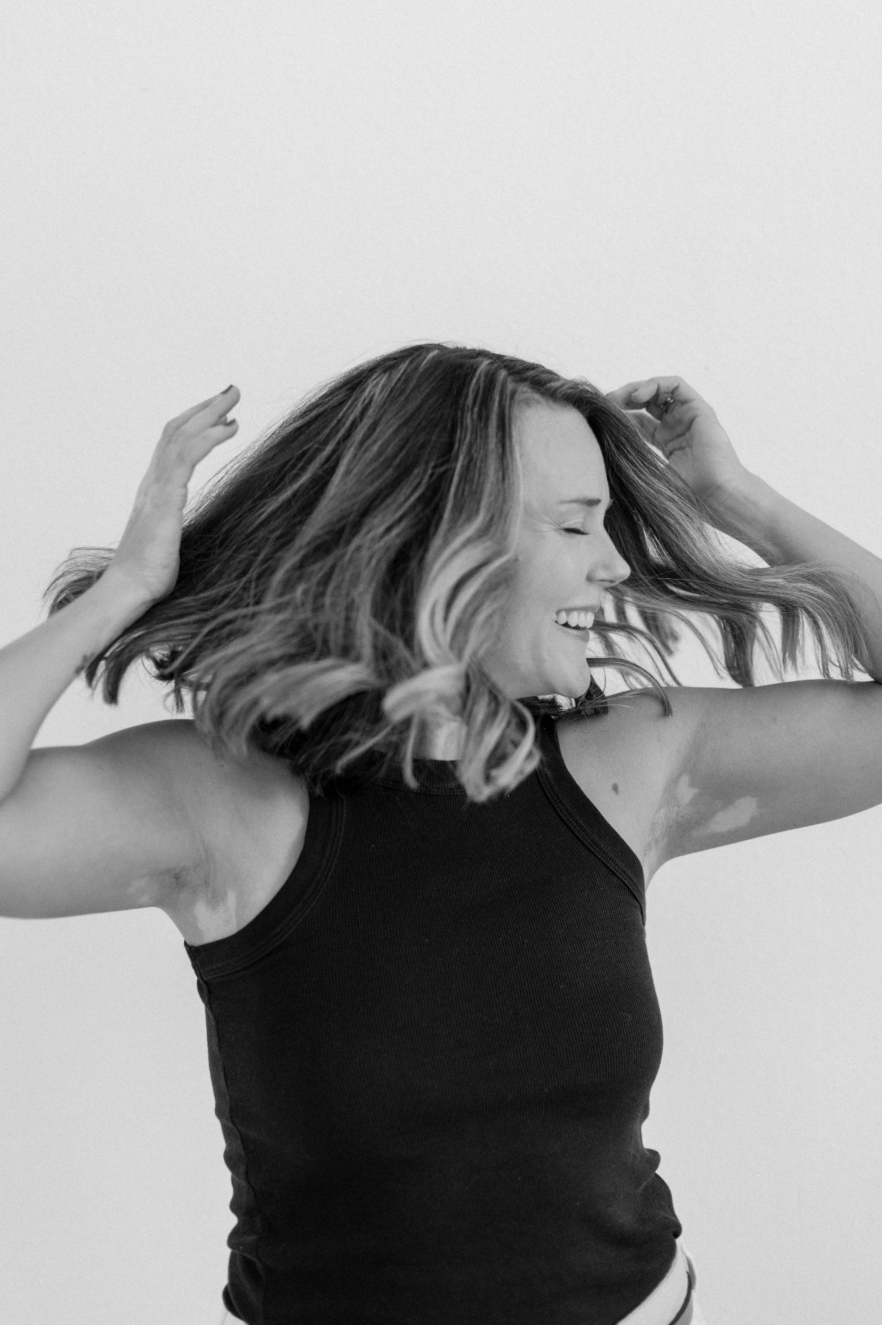 Black and white portrait of a woman shaking out her hair